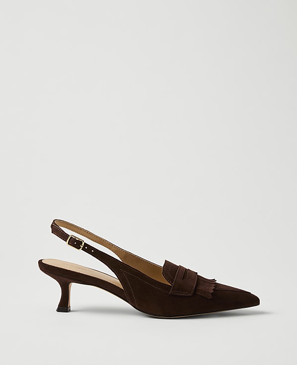A brown suede pointed-toe slingback heel with a tassel detail sits against a plain light gray background.