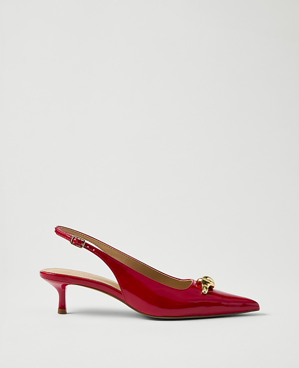 A red patent leather slingback heel with a gold ornament sits against a plain white background.
