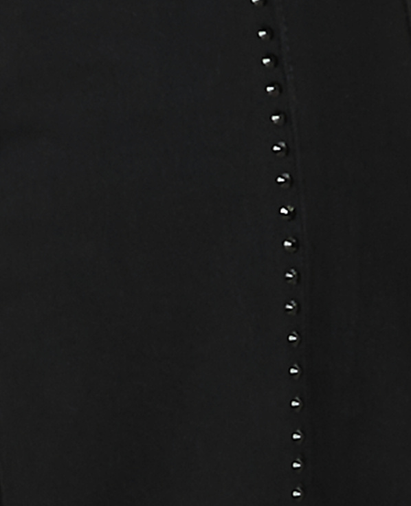 A vertical row of small, shiny studs runs down a black fabric background.
