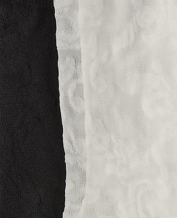 A black textured fabric stands in the foreground against a white textured fabric background.