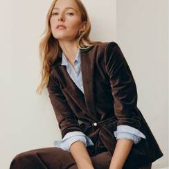 Woman in a brown velvet blazer and light blue shirt