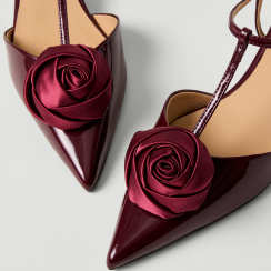 Burgundy satin pointed-toe heels with rosette detail