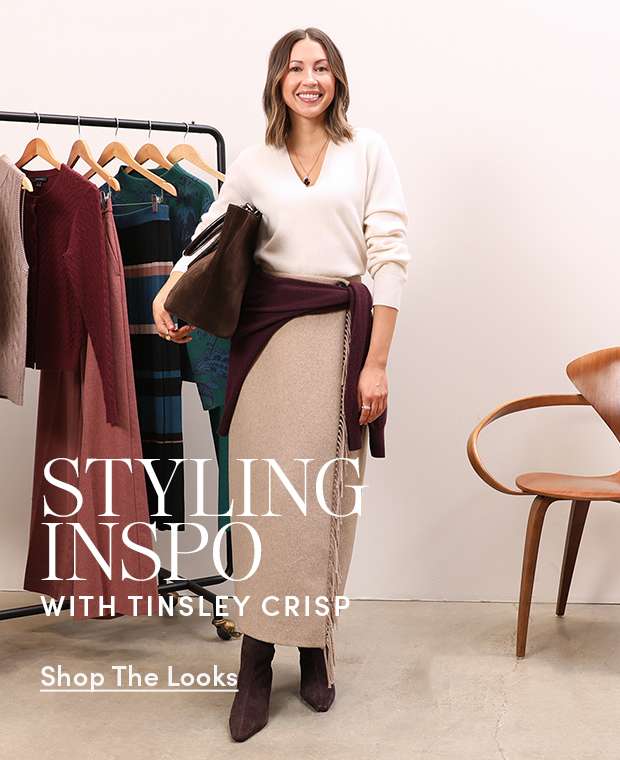 Styling Inspo with Tinsley Crisp — a woman in a cream sweater and tan wrap skirt by a clothing rack. Shop The Looks.
