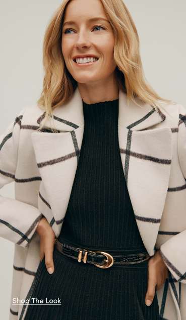 The Outerwear Shop — a woman in a black ribbed dress and white windowpane-check coat. Shop the Look.