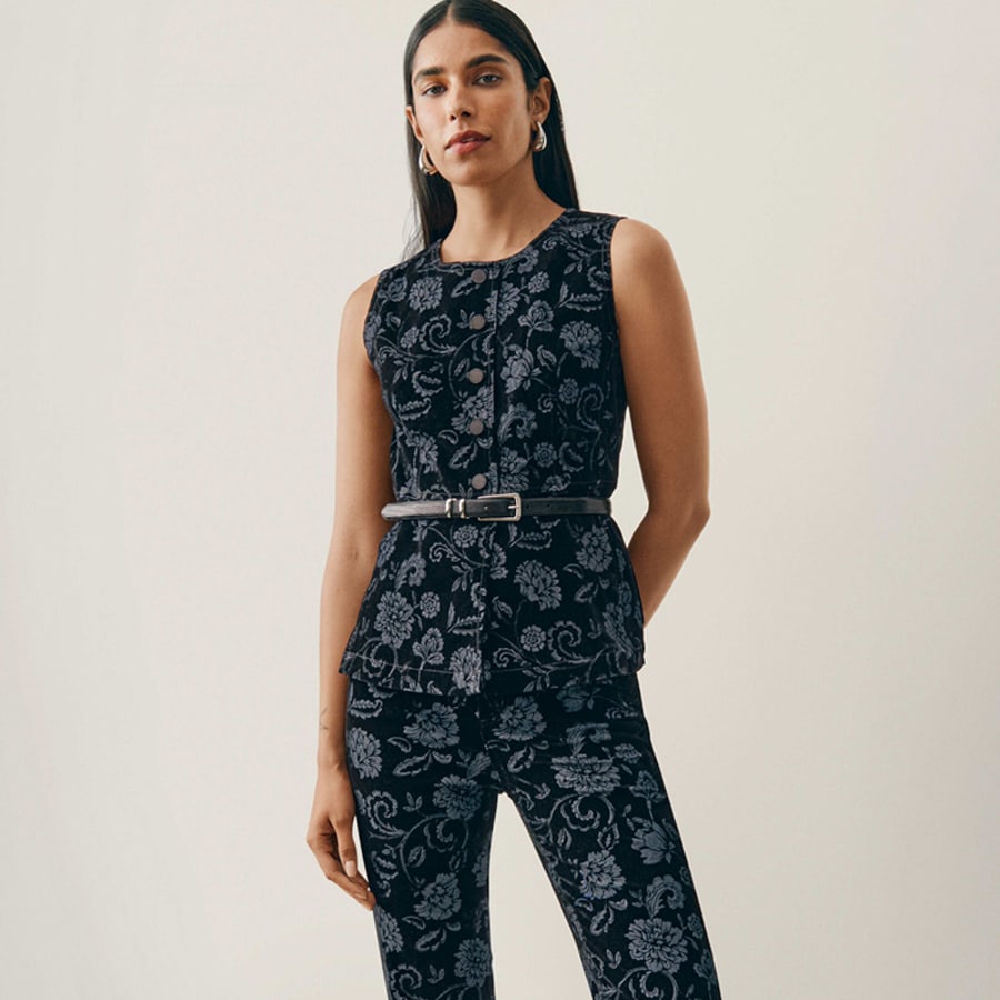 Woman in a matching navy floral jacquard vest and pants